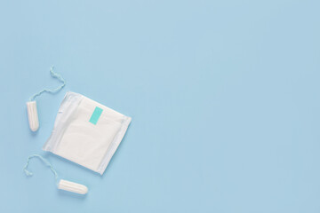 Menstrual pad and tampons on blue background
