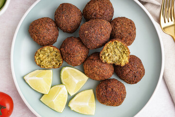 Plate with delicious falafel balls and lime on light background, closeup