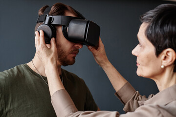 Minimal side view closeup of army veteran wearing VR headset in therapy session with female...