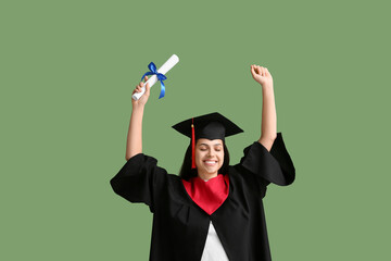 Happy female graduate with diploma on green background