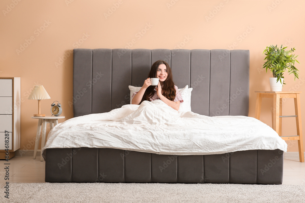 Canvas Prints pretty young woman with cup of tea lying in cozy bed