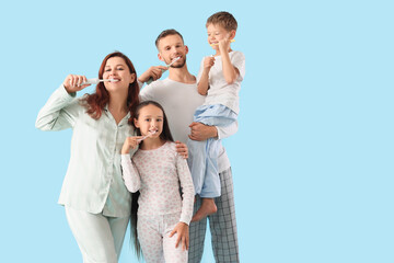 Happy family brushing teeth on blue background