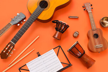 Fototapeta premium Different musical instruments and music notes on orange background