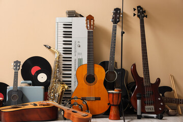 Different musical instruments near beige wall