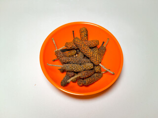 Herbs and spices aromatic dried Piper retrofractum Vahl or cabe jawa in small bowls, close up and isolated on white background.