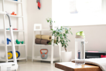 Sports water bottle on bench in gym, closeup