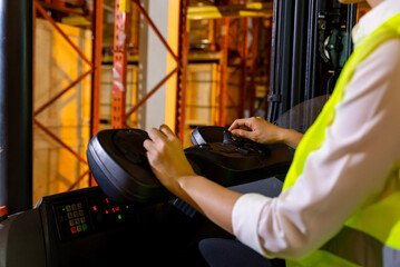 Asian woman warehouse worker working and driving forklift truck checking inventory stock on parcel shelf in distribution fulfillment center. Freight transportation logistic cargo industry concept.