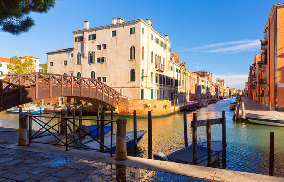 Scenic canal view with a wooden bridge and colorful buildings in the Canareggio District, Venice, Italy - Powered by Adobe