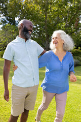 Walking outdoors, man and senior woman smiling and enjoying conversation