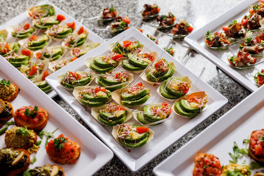 A culinary presentation featuring elegant hors d oeuvres on raised platters.