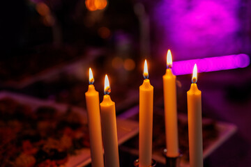 Set of candles burning in a dark room.
