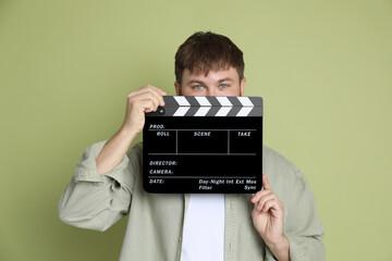 Making movie. Man with clapperboard on green background