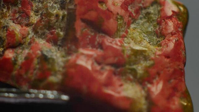 Unakite, green and pink gemstone, symbolizes healing and balance. Composed of epidote, feldspar, and quartz. Chemical formula: Ca2(Al,Fe)3(SiO4)3(OH). Hardness 6-7. Valued for emotional healing