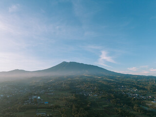 Fototapeta premium Morning view of Mount Gede with light mist and bright clouds, capturing serene and clear beauty