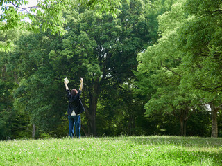 夏の朝の公園で散歩する一人の中年女性の姿