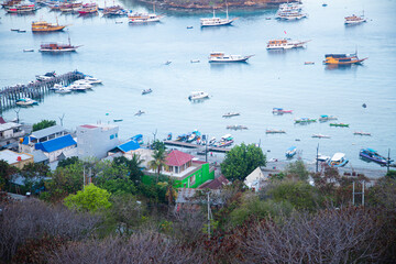 several phinisi boats anchored and lined up beautifully in the waters of Labuan Bajo beach in the afternoon