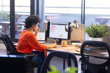 Analyzing department budget on computer screen, female business professional working in office