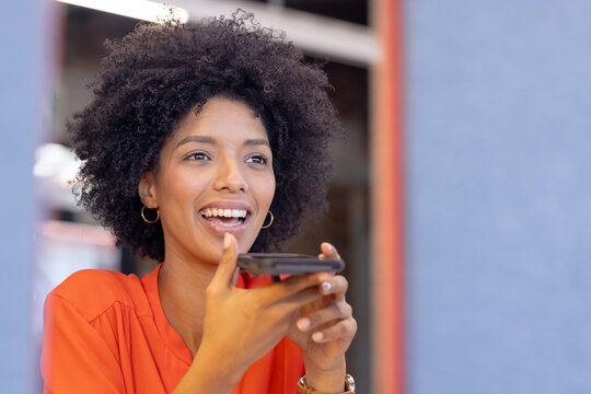 Holding smartphone and speaking, smiling woman engaging in casual business conversation
