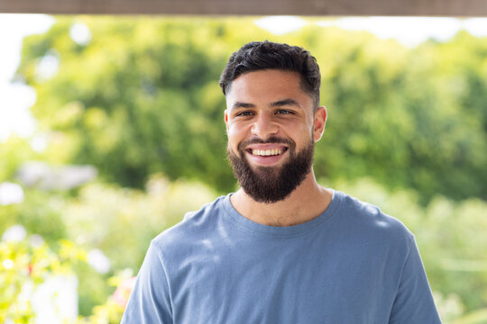 Smiling man standing outdoors, enjoying sunny day in casual attire