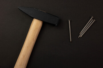 hammer and nails on a black paper