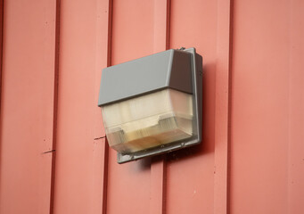 An exterior light on a red wall