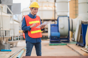 Asian engineer diligently inspects machinery in an industrial factory.Asian workers diligently...