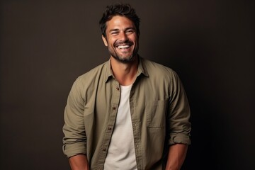 Obraz premium Portrait of a handsome young man laughing against a dark background.