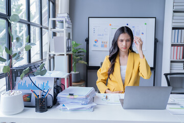 A professional photograph depicting two female entrepreneurs engaged in a collaborative discussion while diligently working in their corporate office environment.