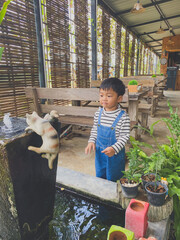 Hispanic child enjoying gardening outdoors with potted plants and watering them in the summer