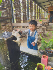 Hispanic child enjoying gardening outdoors with potted plants and watering them in the summer