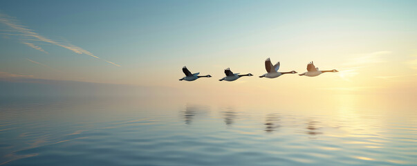 A flock of birds flying in formation over a calm ocean at sunrise, reflecting beautifully on the water.