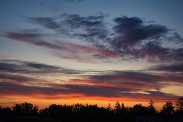 Obraz premium Sun setting casting a golden orange hue upon the clouds