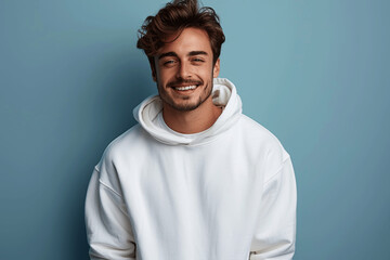 Obraz premium Handsome Man in White Sweatshirt Smiling on Blue Background Pullover Mockup Template for T-Shirt Design