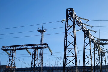 High voltage electric tower on sunny sky background in village. Transmission power line. Parts of...