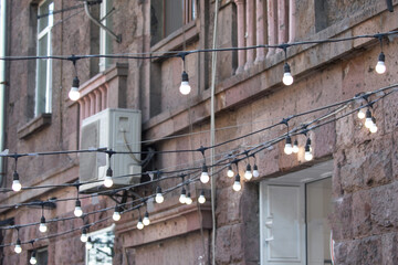 Hanging light bulbs in the street.