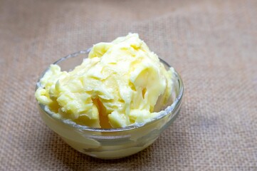 Closeup of Organic Milk Butter Cubes in a Glass Bowl Isolate Burlap Fabric Background with Copy Space