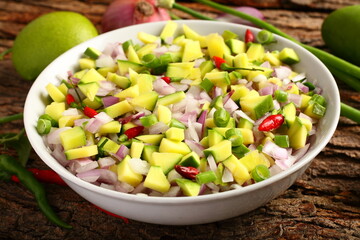 Homemade fresh raw mango salad with herbs and spices.