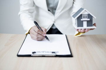 agents working in real estate investment and home insurance signing contracts in accordance with the home buying insurance agreements approving purchases for clients
