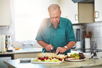 Elderly man, cooking and food for lunch with bread slice, fruit and wellness for retirement in home. Senior person, cheese platter and grapes with health for eating, diet and nutrition in kitchen