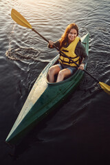 Happy woman, kayak and ocean with paddle above for travel, hobby or outdoor holiday in water, lake or nature. Top view of young female person, rowing boat and smile for canoeing or adventure at sea © ReeseArcurs/peopleimages.com