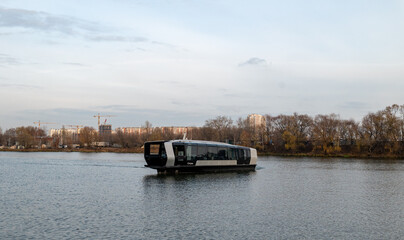 Electric river tram on the Moskva River at sunset on an autumn evening.