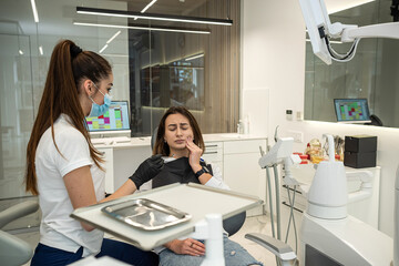 Attractive young woman feels a toothache and visits a female dentist.