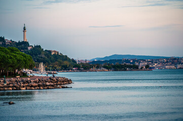 Naklejka premium Historic city of Trieste. Between ancient buildings and reflections on the sea. Autumn day and celebration of the Barcolana International Regatta.