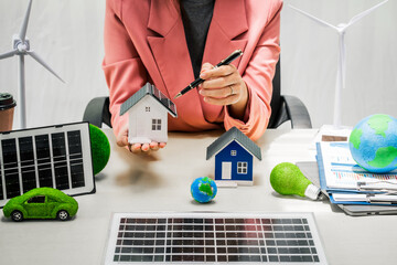 Female entrepreneur working at desk in clean energy sector Focusing on wind turbines solar energy...