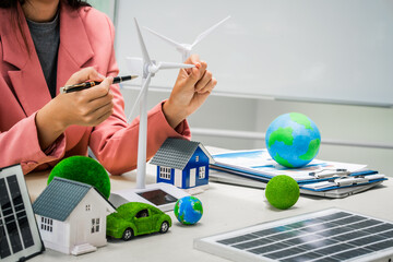Female entrepreneur working at desk in clean energy sector Focusing on wind turbines solar energy...