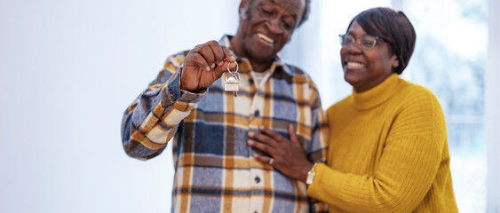 Obraz premium Elderly Couple Celebrating New Home with Keys
