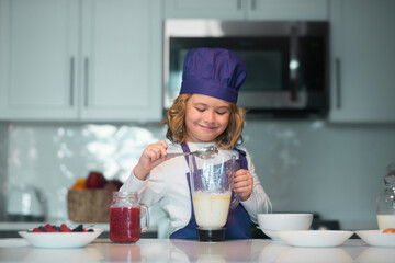 Child chef cooking meal. Kid making tasty delicious. little boy in chef hat and an apron cooking in the kitchen.