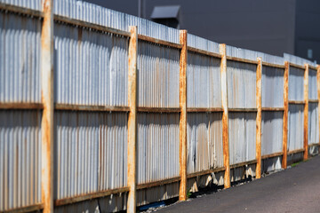 Rusty metal fence outside a warehouse.