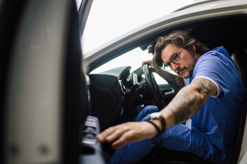 Doctor getting into car, going home from work, closing car doors. Work-life balance of healthcare worker.