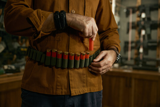 Closeup of hunter hands placing bullets into the ammo belt